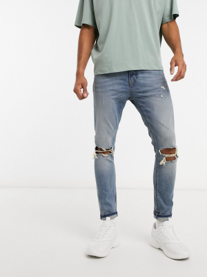 Asos Design Cropped Super Skinny Jeans In Mid Blue With Knee Rips