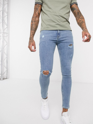 Asos Design Spray On Jeans In Power Stretch Denim In Light Wash Blue With Abrasions