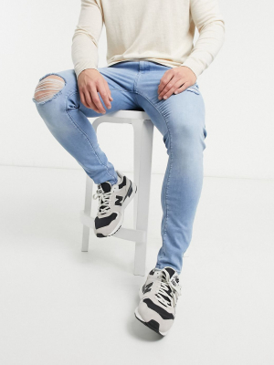 Asos Design Spray On Jeans With Power Stretch Denim In Light Wash Blue With Abrasions