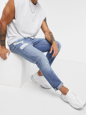 Asos Design Slim Jeans In Mid Wash With Abrasions