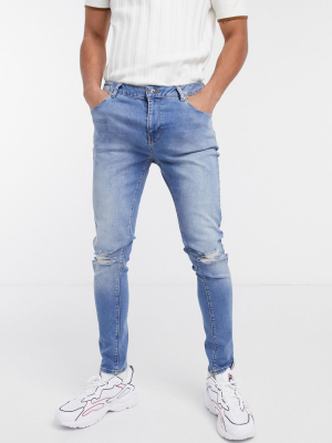 Asos Design Spray On Jeans With Power Stretch In Mid Wash Blue With Rips