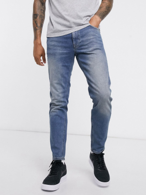 Asos Design Stretch Tapered Jeans In Mid Wash Blue Tint