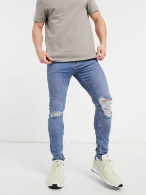 Asos Design Spray On Jeans With Power Stretch Denim In Light Wash Blue With Heavy Rips