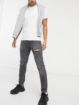 Asos Design Slim Jeans In Washed Black With Abrasions And Thigh Rip