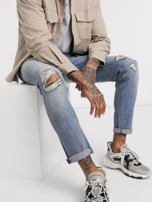 Asos Design Skinny Jeans In Mid Wash With Mid Rips And Raw Hem