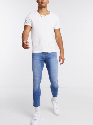 Asos Design Extreme Cropped Spray-on Jeans With Power Stretch In Mid Blue With Raw Hem