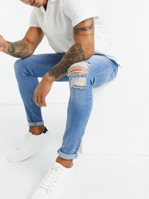 Asos Design Spray On Jeans With Power Stretch In Vintage Mid Wash Blue With Knee Rips