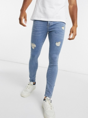 Asos Design Spray On Jeans With Power Stretch In Light Wash Blue With Abrasions