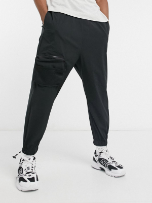 Asos Design Oversized Tapered Sweatpants With Cargo Pockets In Black