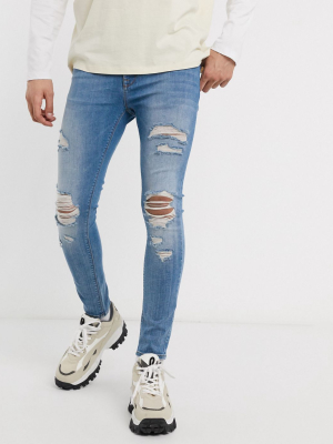 Asos Design Spray On Jeans With Power Stretch In Light Wash Blue With Heavy Rips