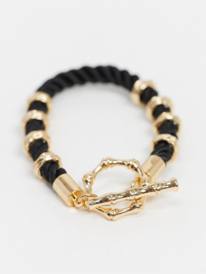 Asos Design T Bar Bracelet With Rope And Bamboo Design In Black And Gold Tone