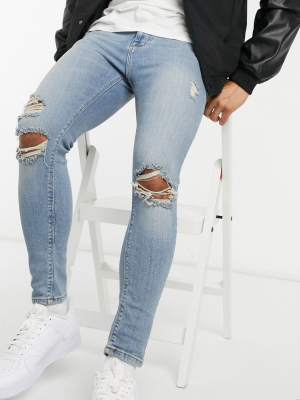 Asos Design Spray On'vintage Look' Jeans With Power Stretch In Mid Wash Blue With Knee Rips