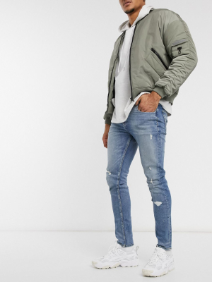 Asos Design Skinny Jeans In Tinted Light Wash Blue With Rips